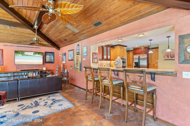 interior space with kitchen peninsula, stainless steel appliances, wooden ceiling, and a breakfast bar area