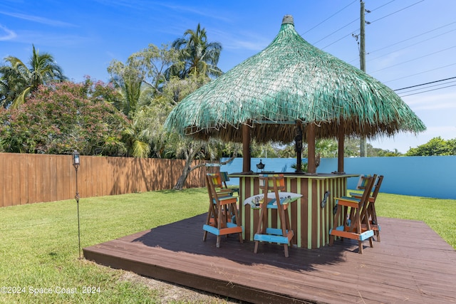 wooden deck featuring exterior bar and a lawn