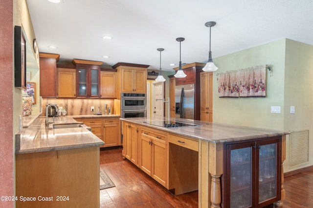 kitchen with light stone countertops, stainless steel appliances, dark hardwood / wood-style floors, and sink