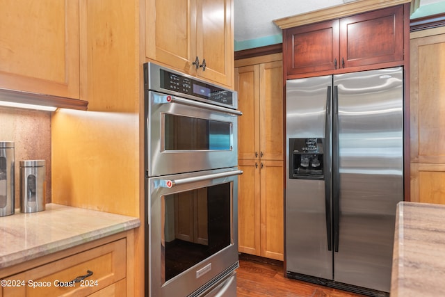 kitchen featuring light stone counters, stainless steel appliances, and dark hardwood / wood-style floors