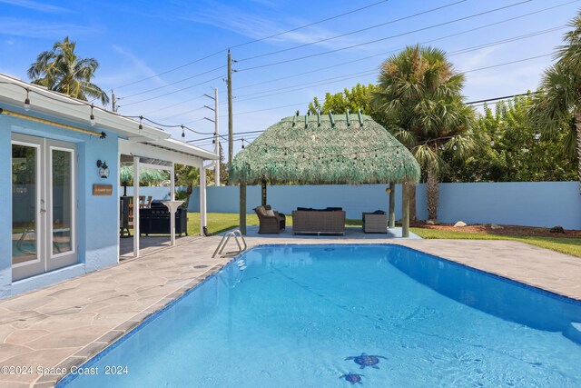 view of swimming pool featuring french doors, an outdoor living space, and a patio