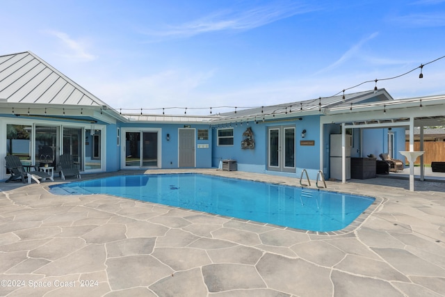 view of pool featuring a patio area and french doors