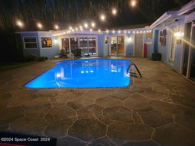 pool at twilight with a patio