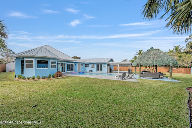 rear view of house with a fenced in pool, a patio area, a yard, and an outdoor hangout area