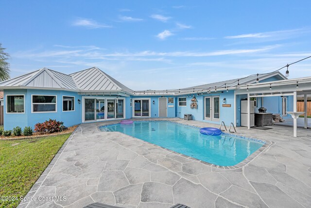 view of pool with a patio area and french doors