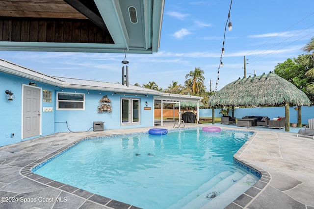 view of pool featuring a gazebo, outdoor lounge area, a patio area, and french doors