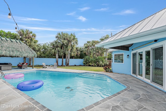 view of swimming pool featuring a lawn, an outdoor hangout area, a gazebo, a grill, and a patio