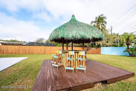 wooden terrace with a lawn and a bar