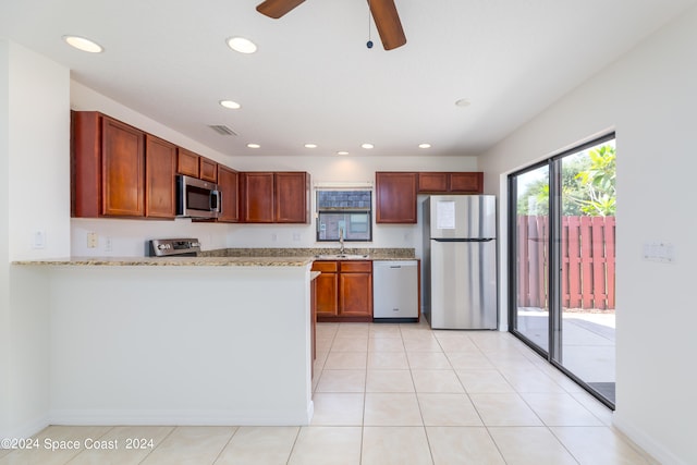 kitchen with appliances with stainless steel finishes, light tile patterned floors, sink, and ceiling fan