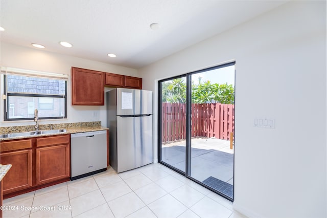 kitchen with light tile patterned floors, stainless steel refrigerator, sink, and dishwasher