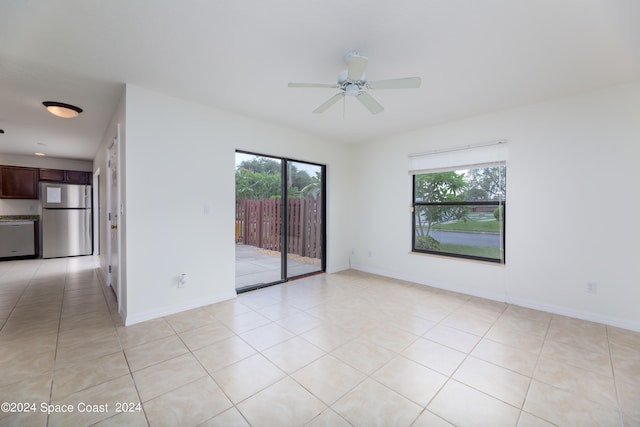 spare room with ceiling fan and light tile patterned floors