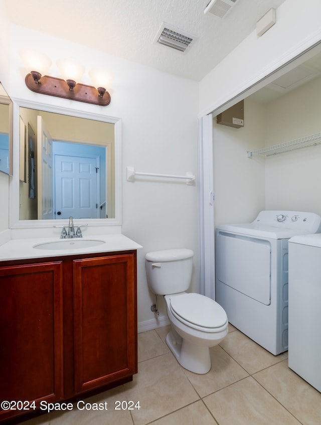 bathroom featuring a textured ceiling, toilet, washer and dryer, tile patterned flooring, and vanity