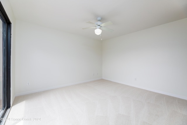 empty room featuring ceiling fan and light colored carpet