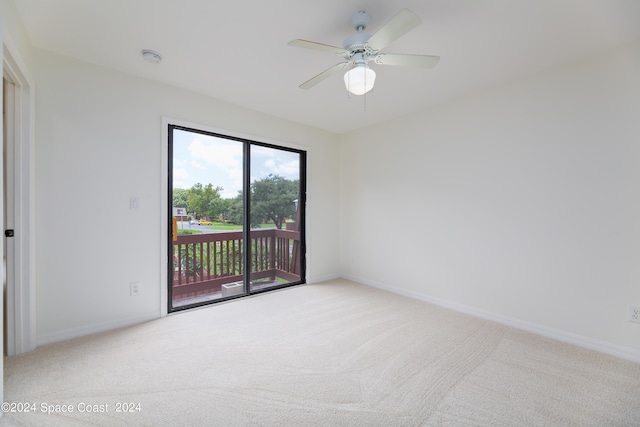 carpeted spare room featuring ceiling fan