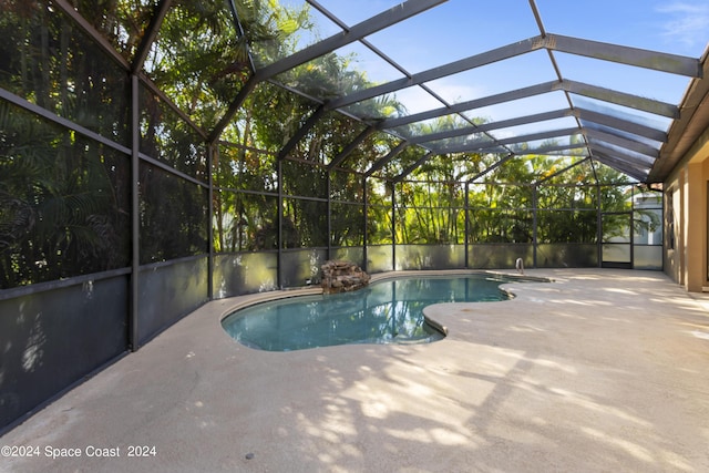 pool with glass enclosure and a patio area