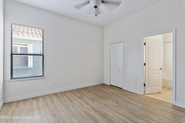 unfurnished bedroom with ensuite bathroom, ceiling fan, wood finished floors, baseboards, and a closet