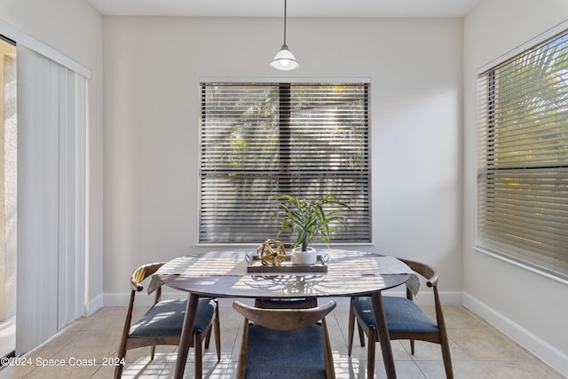 dining space featuring light tile patterned flooring and baseboards