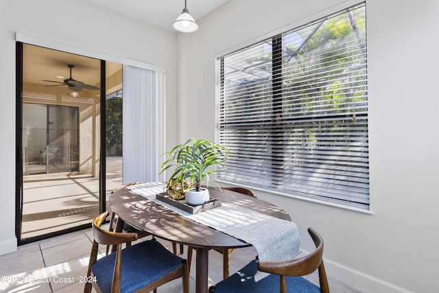 dining space featuring a ceiling fan, baseboards, and light tile patterned floors