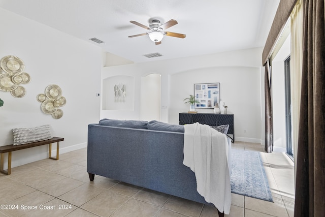 living area featuring baseboards, light tile patterned flooring, visible vents, and a ceiling fan