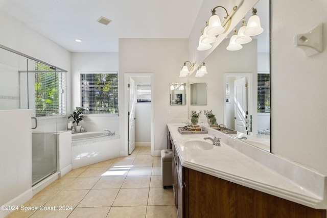 bathroom with double vanity, a stall shower, tile patterned floors, a garden tub, and a sink