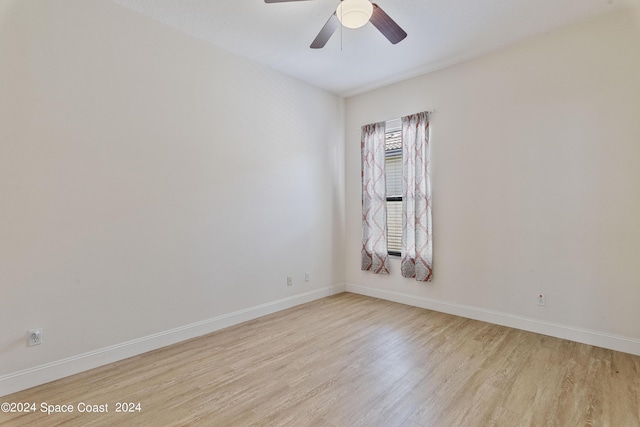 unfurnished room with ceiling fan, light wood-style flooring, and baseboards