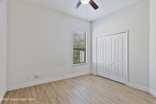 unfurnished bedroom with ceiling fan, a closet, wood finished floors, and baseboards