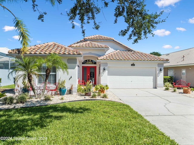 mediterranean / spanish-style house with a garage and a front lawn