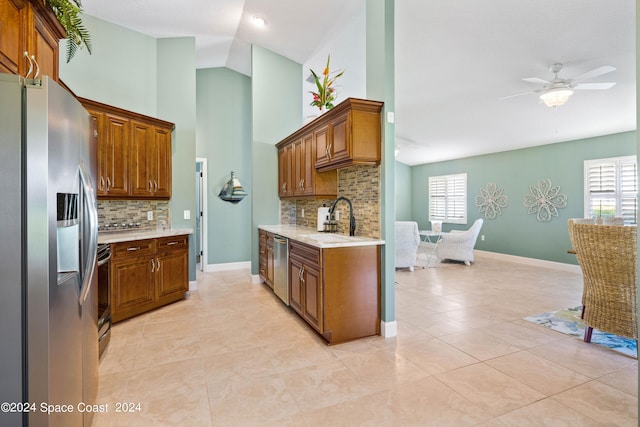 kitchen with appliances with stainless steel finishes, brown cabinets, light countertops, and a sink