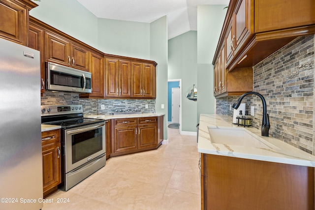 kitchen featuring brown cabinets, stainless steel appliances, and a sink