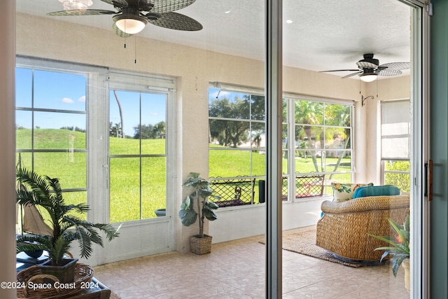 sunroom / solarium featuring a healthy amount of sunlight and a ceiling fan