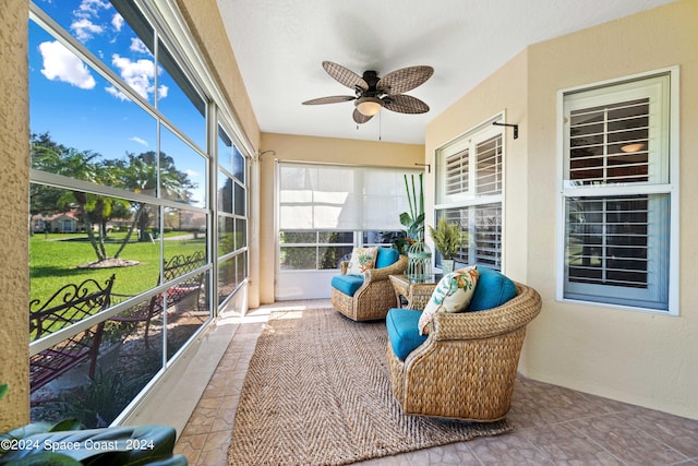 sunroom / solarium featuring a ceiling fan