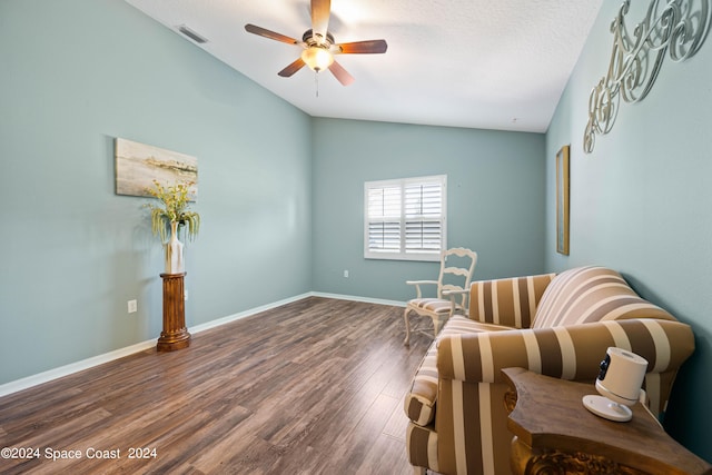 living area featuring lofted ceiling, visible vents, ceiling fan, wood finished floors, and baseboards