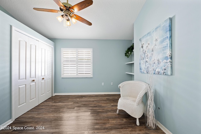 sitting room with a ceiling fan, dark wood-style flooring, and baseboards