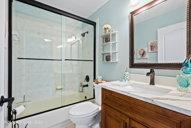 full bathroom with toilet, bath / shower combo with glass door, a textured ceiling, and vanity