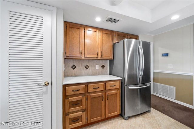 kitchen featuring stainless steel refrigerator, light tile patterned flooring, and tasteful backsplash