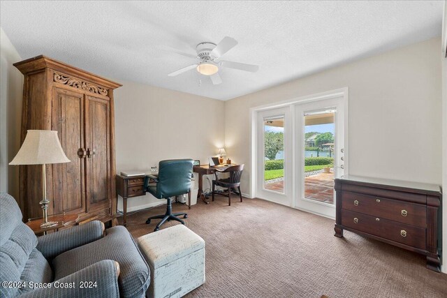 office area with carpet floors, ceiling fan, and a textured ceiling