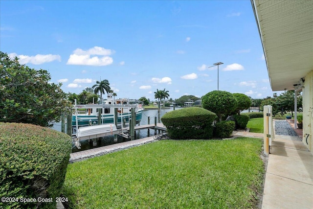 view of dock with a water view and a yard