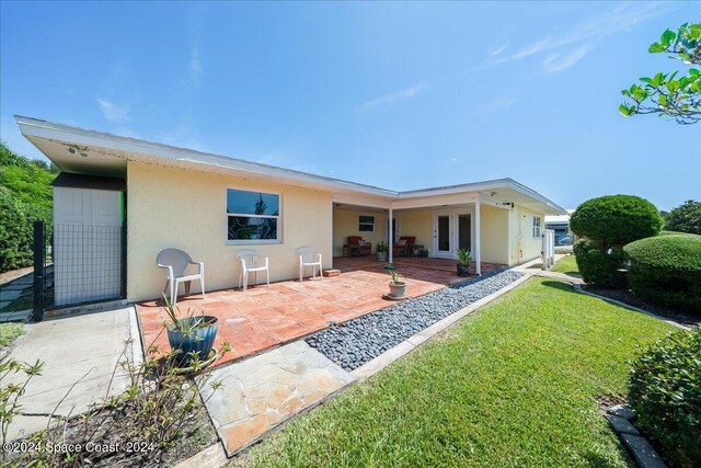 rear view of property with a lawn