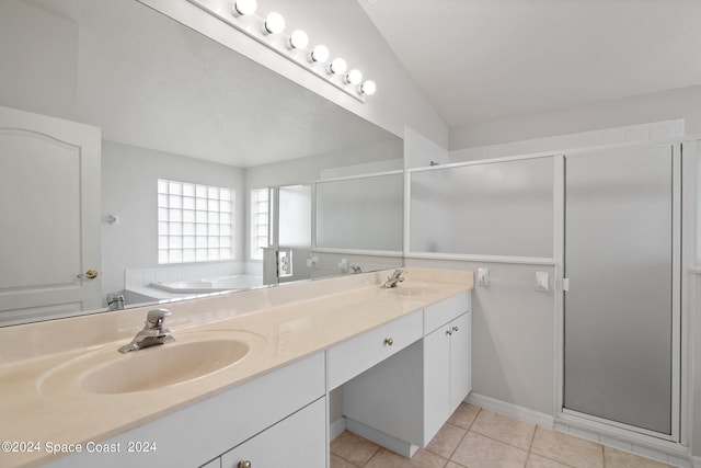 bathroom with vaulted ceiling, tile patterned flooring, double vanity, and independent shower and bath