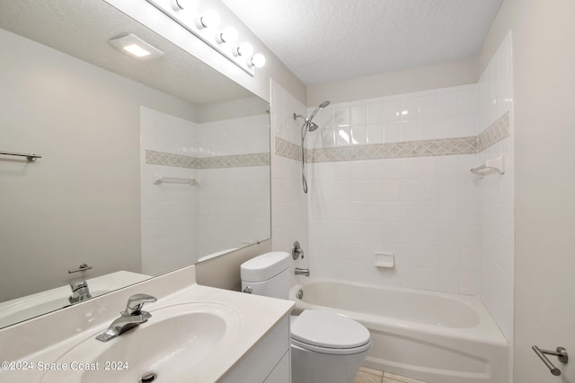 full bathroom featuring toilet, vanity, tile patterned floors, a textured ceiling, and tiled shower / bath combo