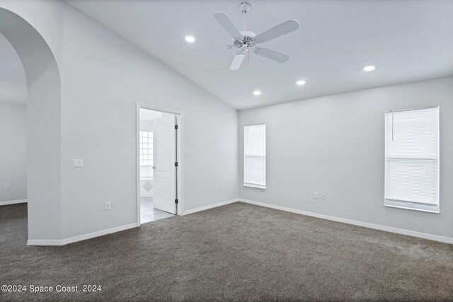 carpeted spare room featuring ceiling fan and lofted ceiling