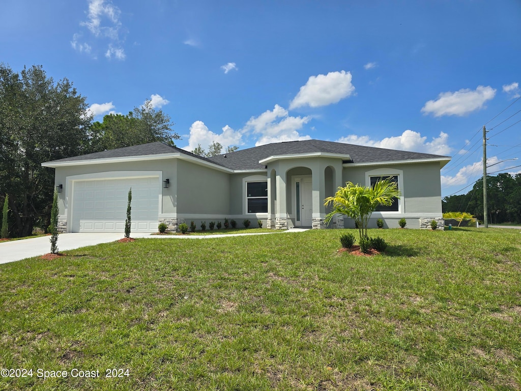 view of front of house featuring a garage and a front lawn