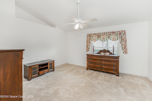 interior space featuring ceiling fan, vaulted ceiling, and light colored carpet