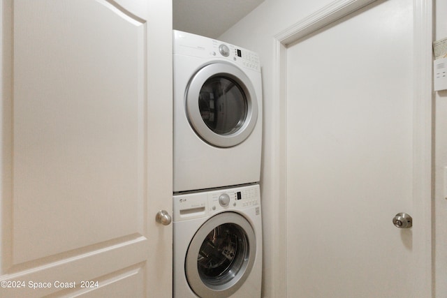 clothes washing area featuring stacked washer and dryer