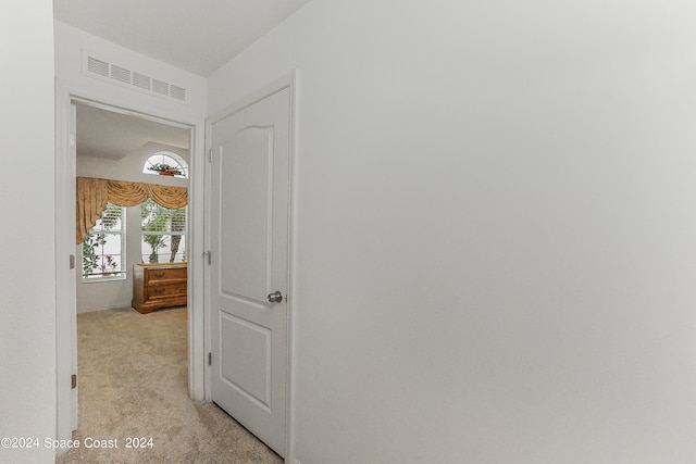 hallway featuring light colored carpet