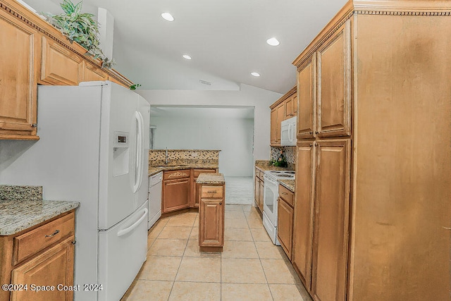 kitchen featuring lofted ceiling, light stone counters, light tile patterned flooring, and white appliances