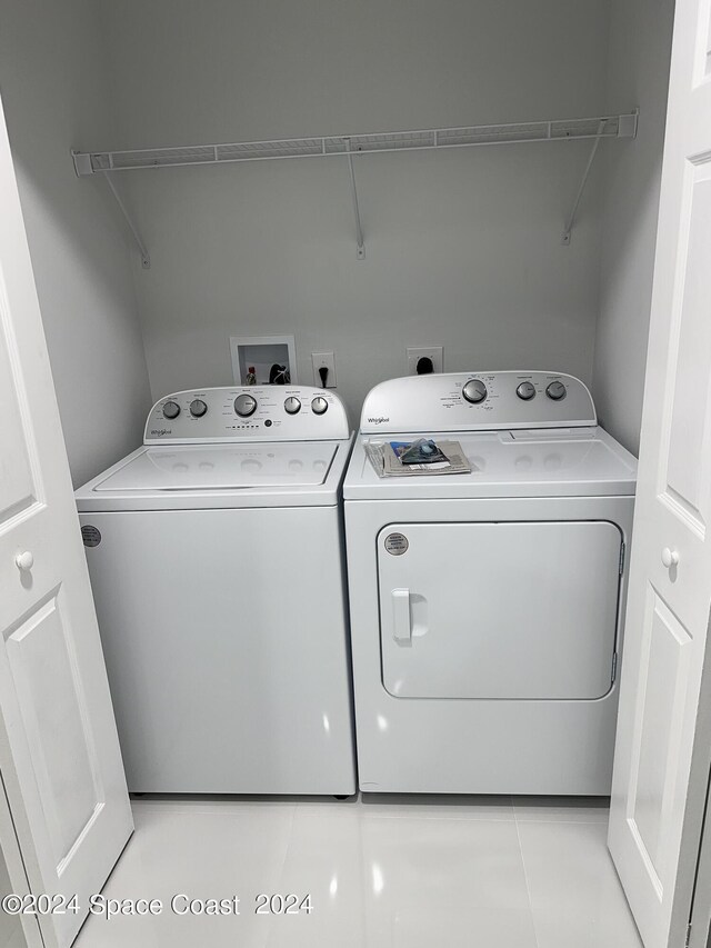 laundry area with laundry area, light tile patterned floors, and separate washer and dryer