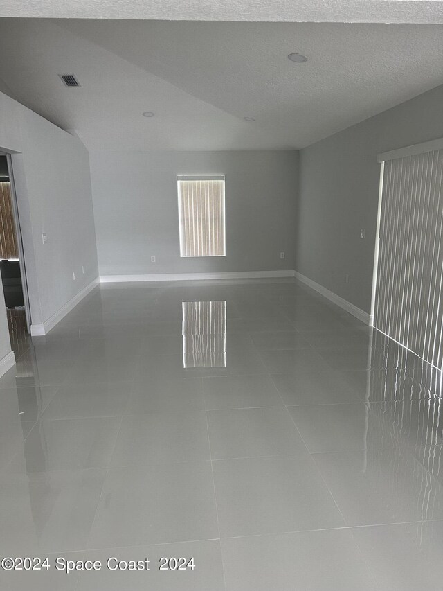 unfurnished room with visible vents, baseboards, a textured ceiling, and tile patterned floors