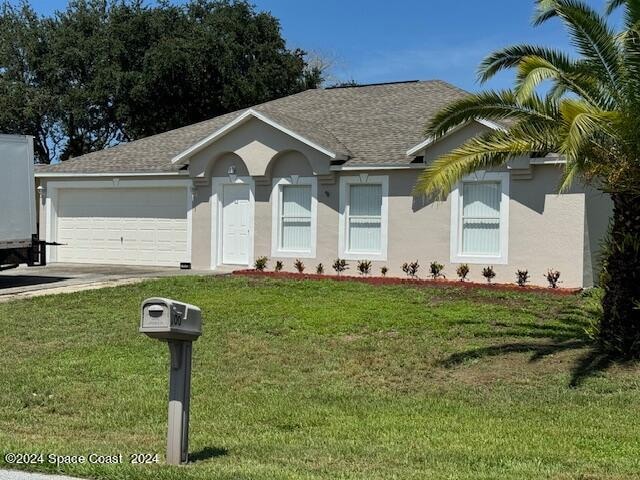 ranch-style home with a garage and a front yard