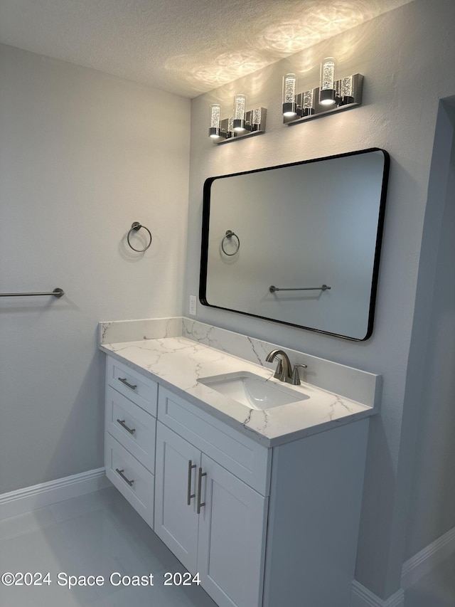 bathroom with a textured ceiling and vanity